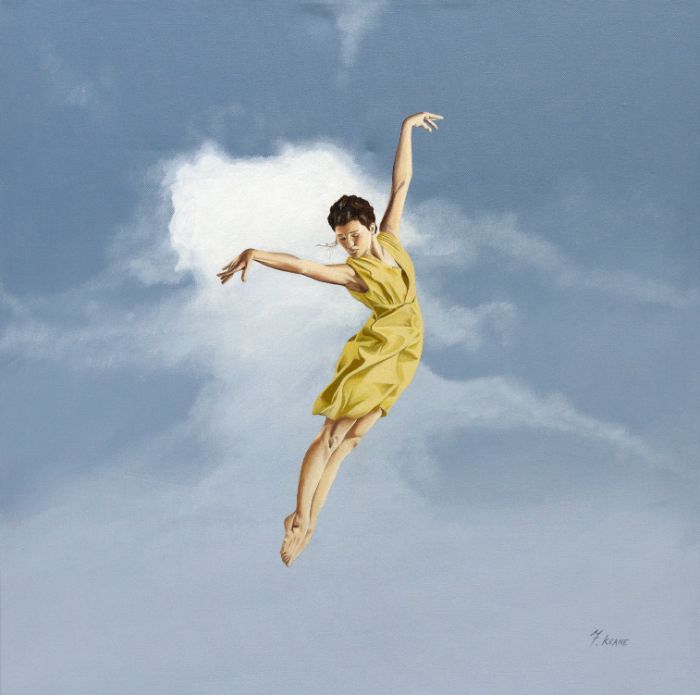 Dancer in a yellow dress suspended against a pale sky